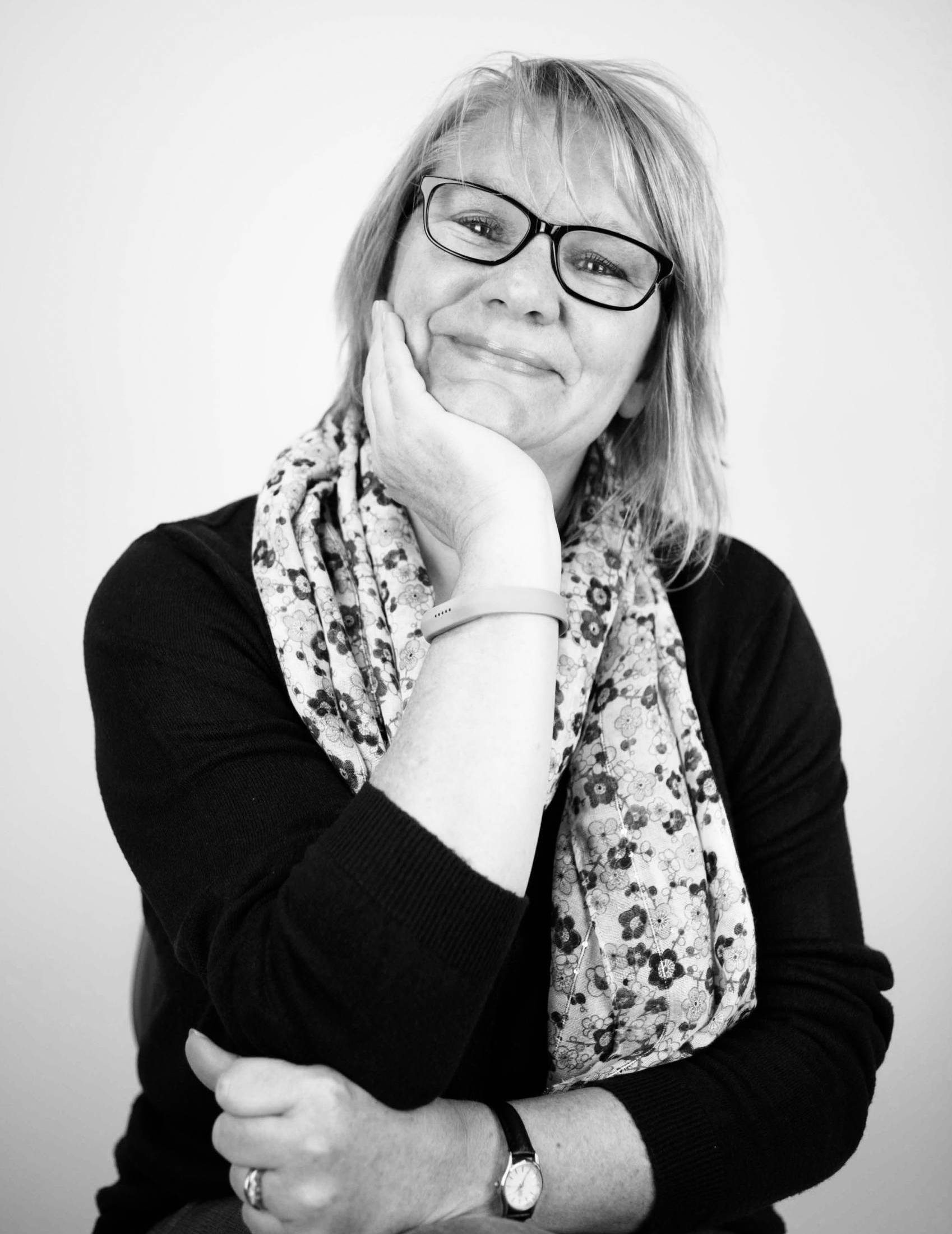A black and white image of Ros smiling towards camera