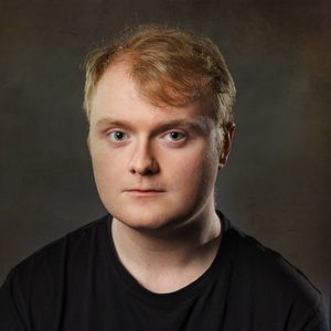 Shane is looking at the camera.