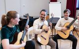 Guitar students performing in a classroom.