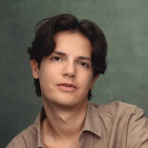 David is looking at the camera.