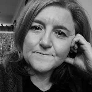 Nicola is looking at the camera. The image is black and white.