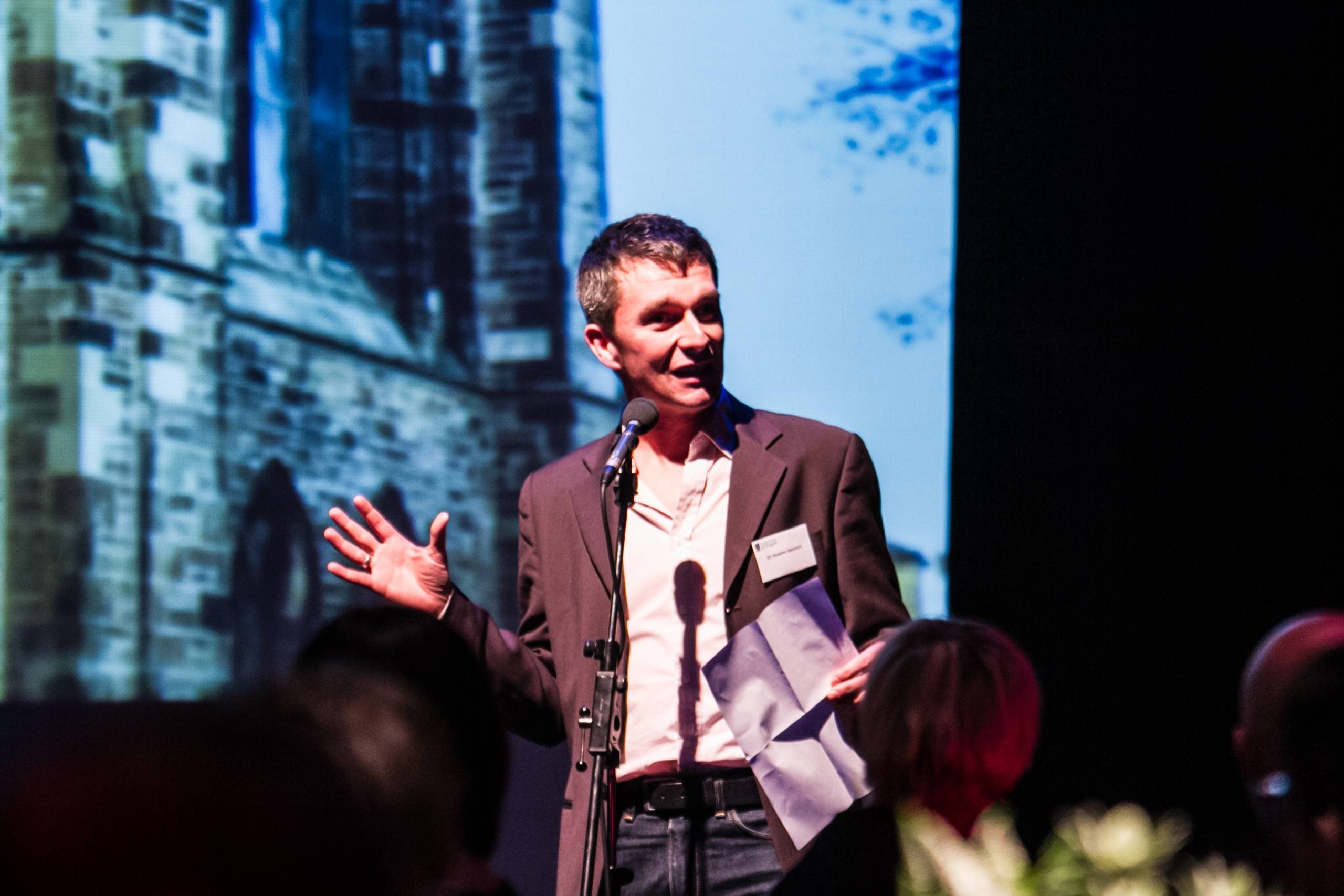 Anselm Heinrich is standing in front of a microphone.