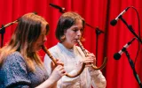 Two performers playing the Crumhorn.