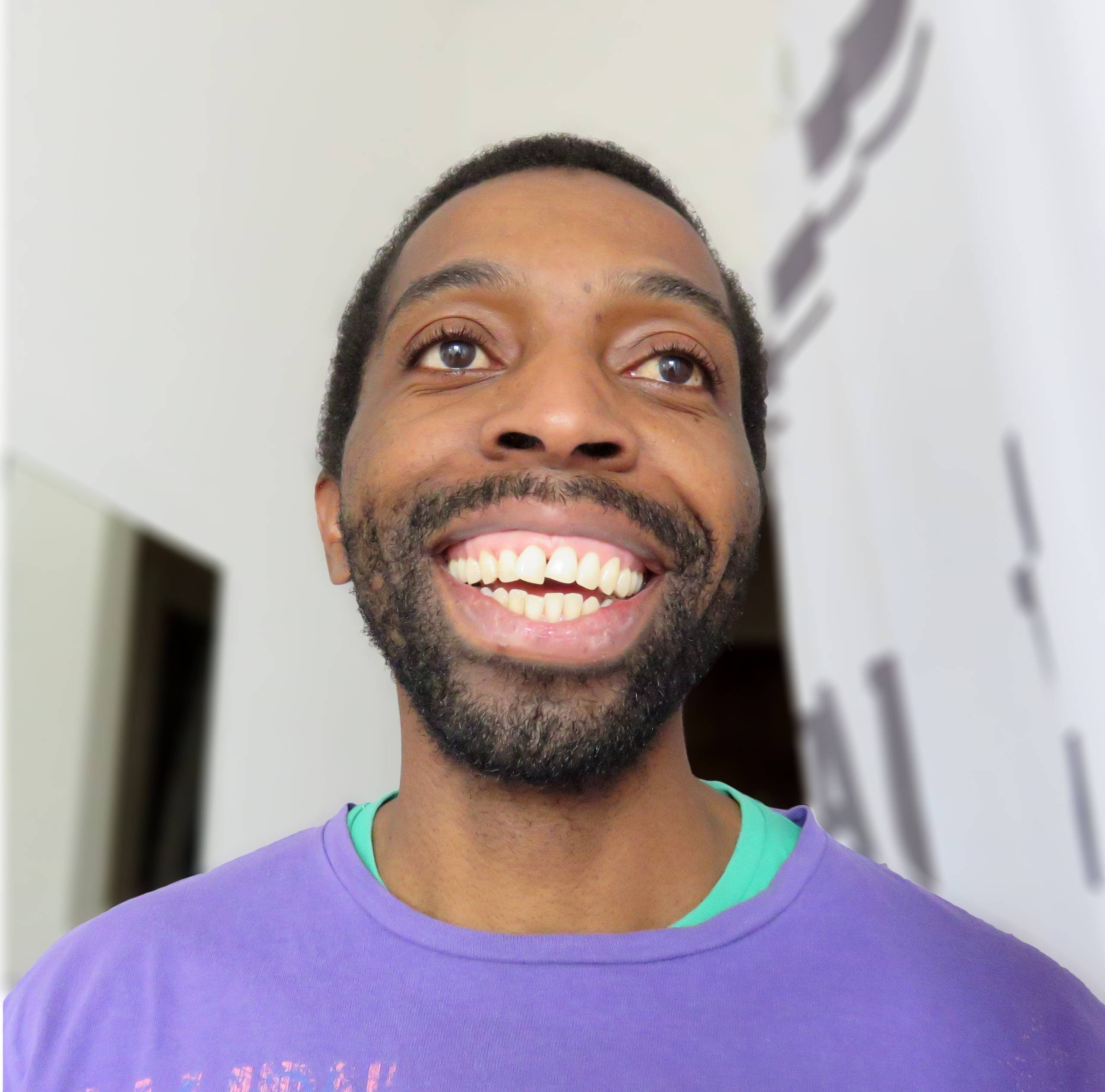 Tawona is smiling at the camera. He is wearing a blue jumper.