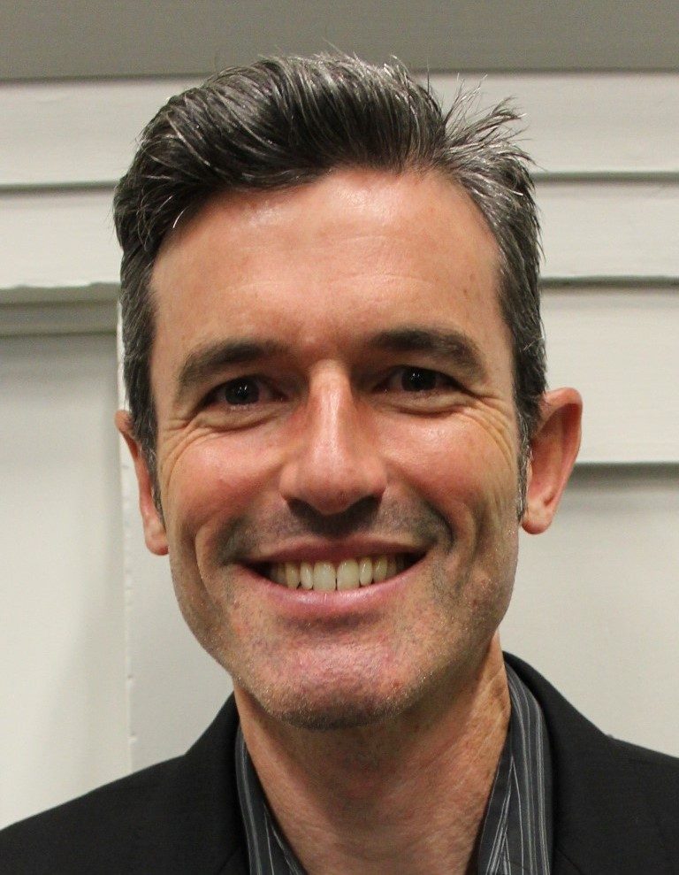 Alex South is smiling at the camera.