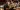 Photograph of orchestra with focus on french horn players.