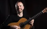 Lorenzo Micheli sat smiling with guitar